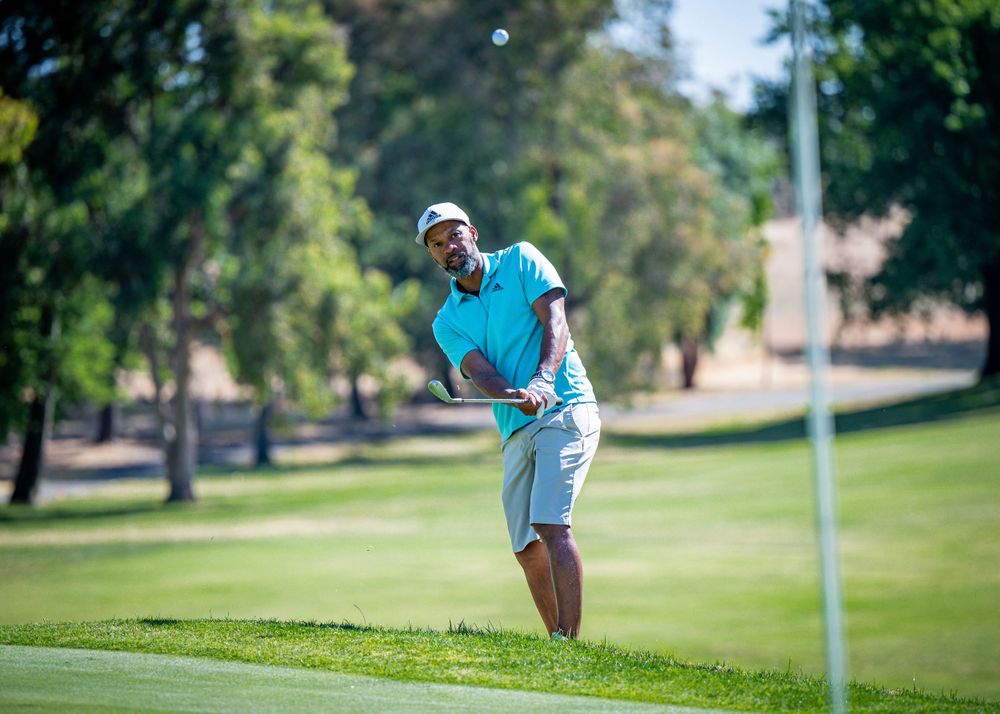 Golfer hitting ball to green.