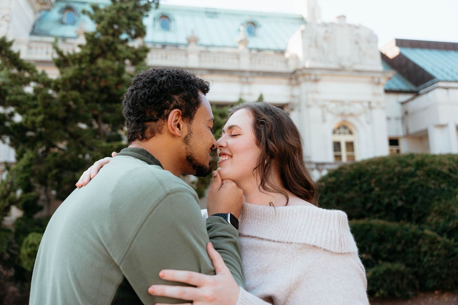 Romantic winter photoshoot in front of classic white architecture.