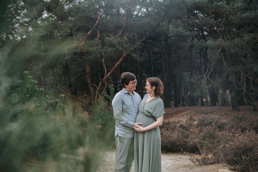 Intimate maternity portrait in forest setting with natural lighting.