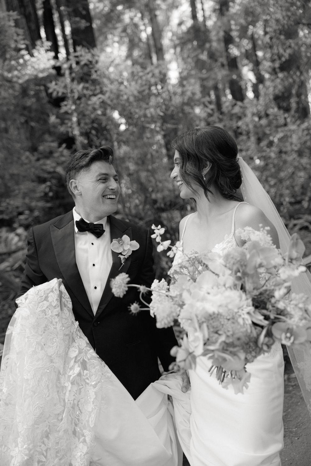 Black and white wedding portrait captured in a dreamy woodland setting.