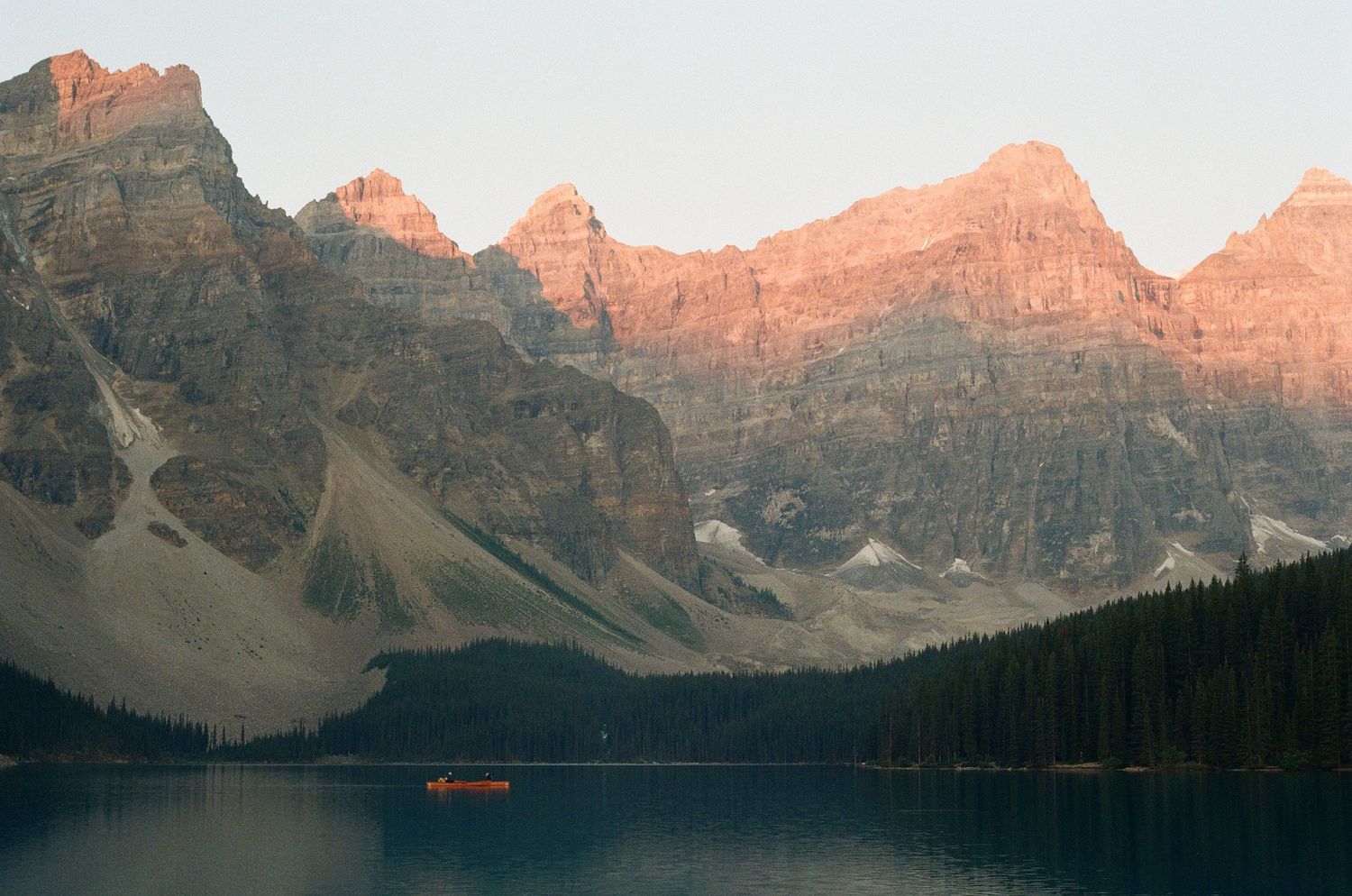 A sunrise photo of the sun slowly coming down onto the mountain at Moraine Lake in Banff Canada