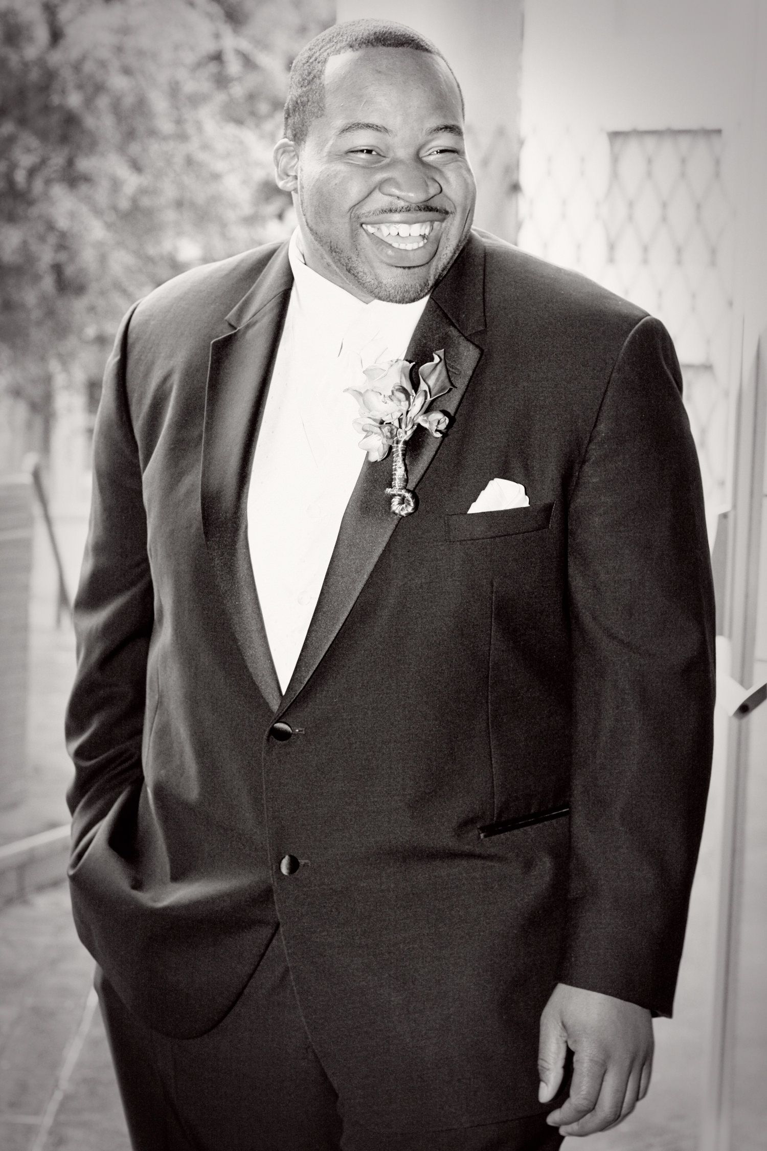 Black and white portrait of someone in formal attire with a warm smile.