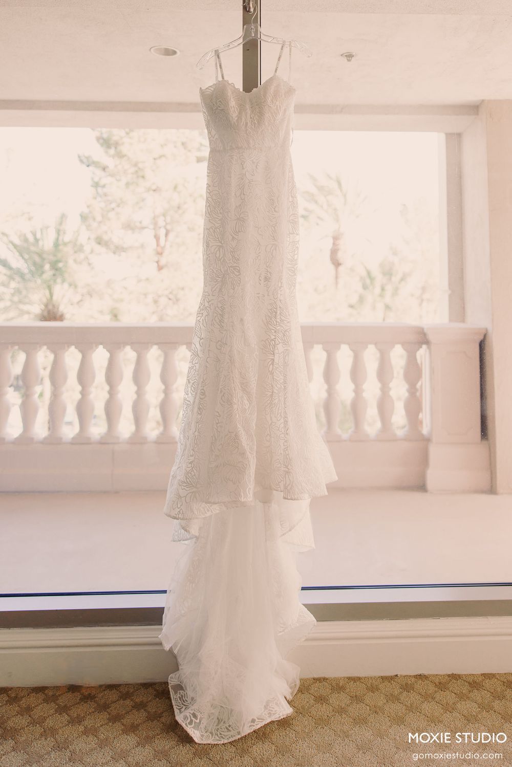 Close-up sequence showing flowing white lace wedding dress details against a bright window backdrop.