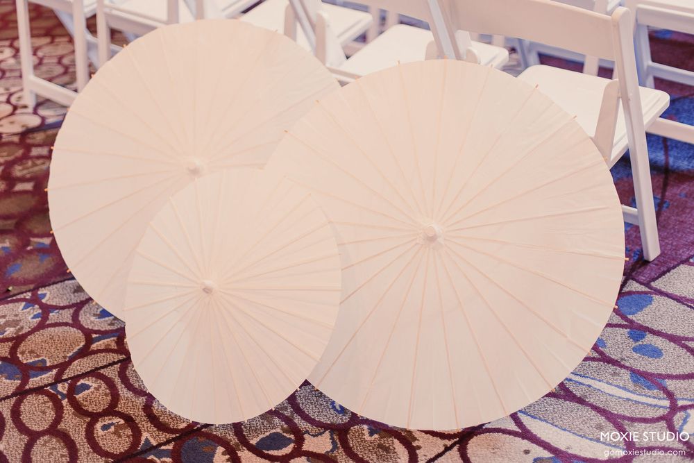 A row of white paper umbrellas displayed at a traditional Japanese festival or market setting.