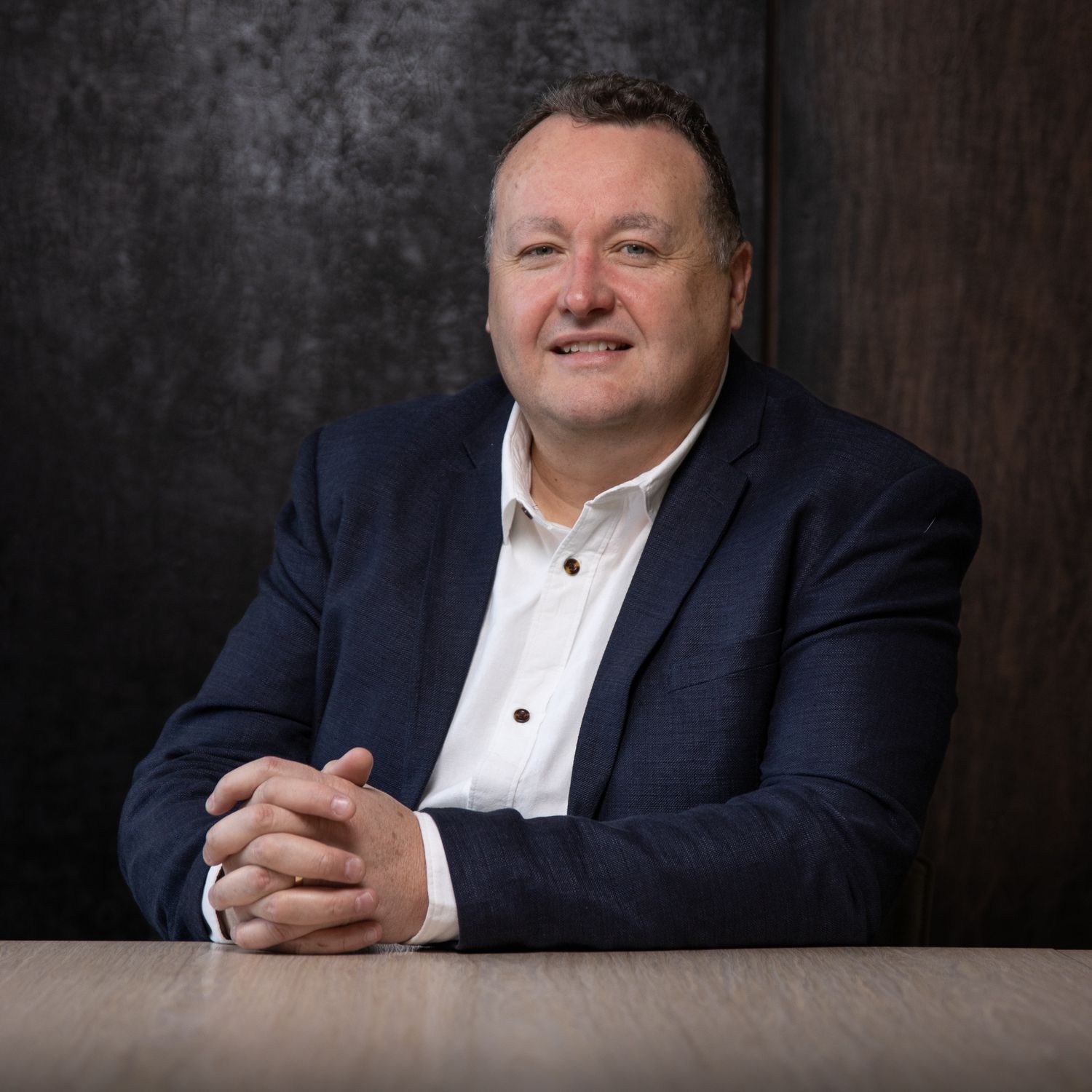 Business professional headshot with confident expression and studio lighting