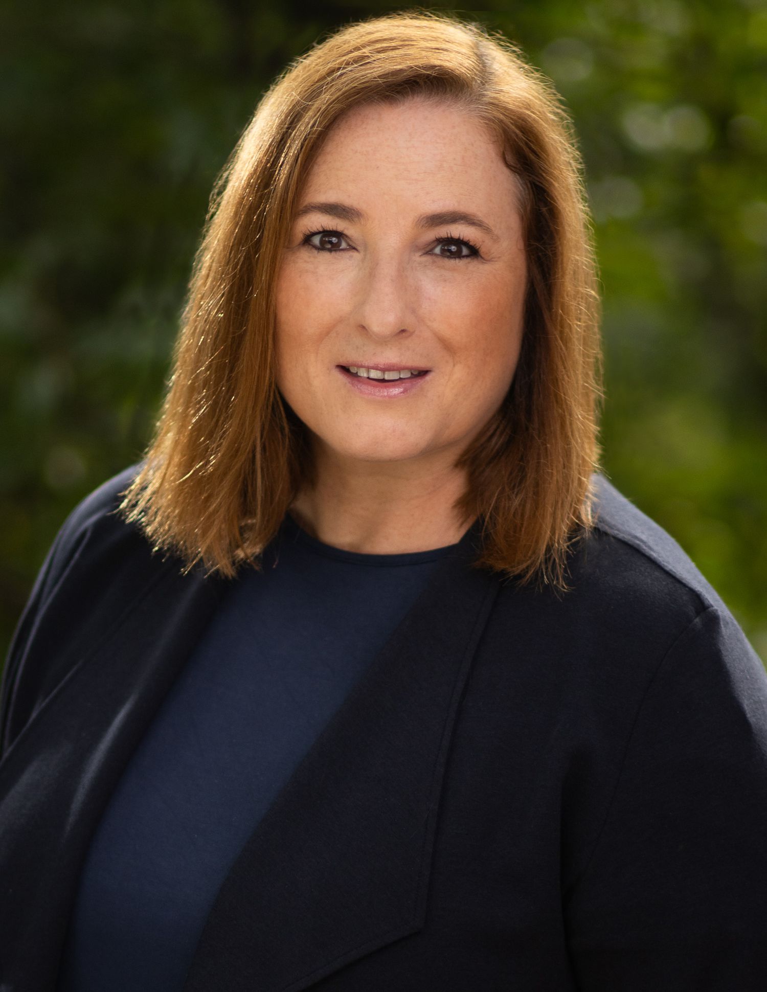 Business professional headshot with confident expression and studio lighting