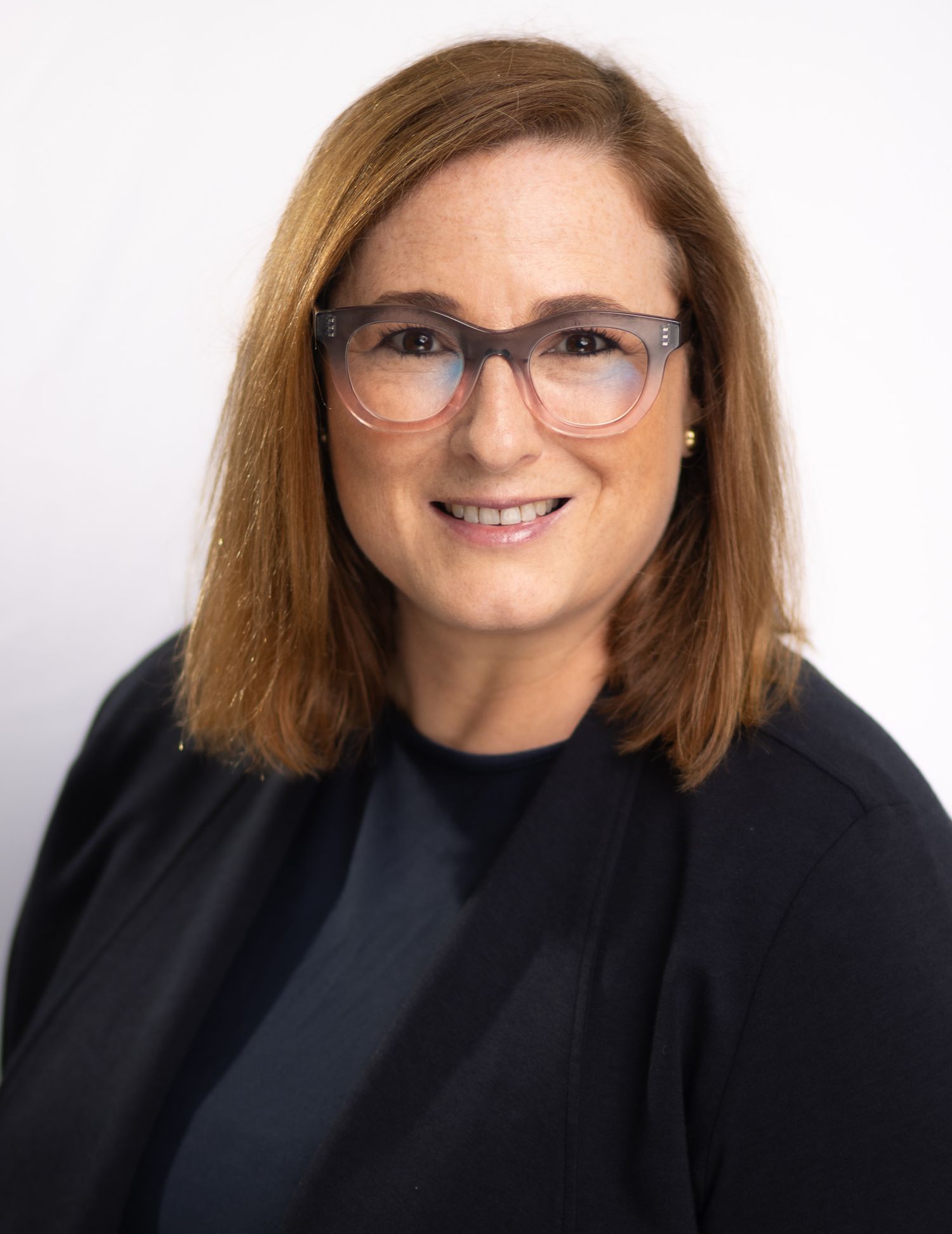 Business professional headshot with confident expression and studio lighting
