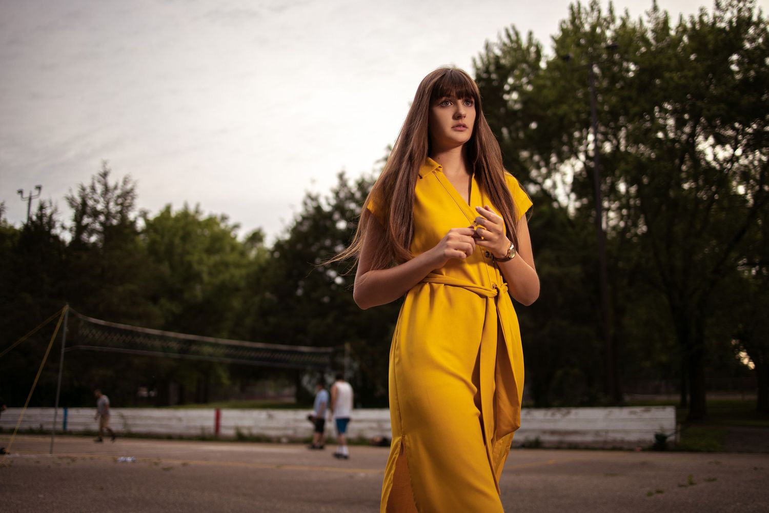 beautiful female model cat walking across the soccer filed players in the back