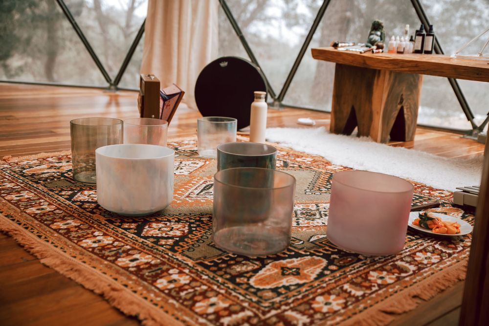 White candles and decorative elements arranged on a patterned rug in an indoor setting.