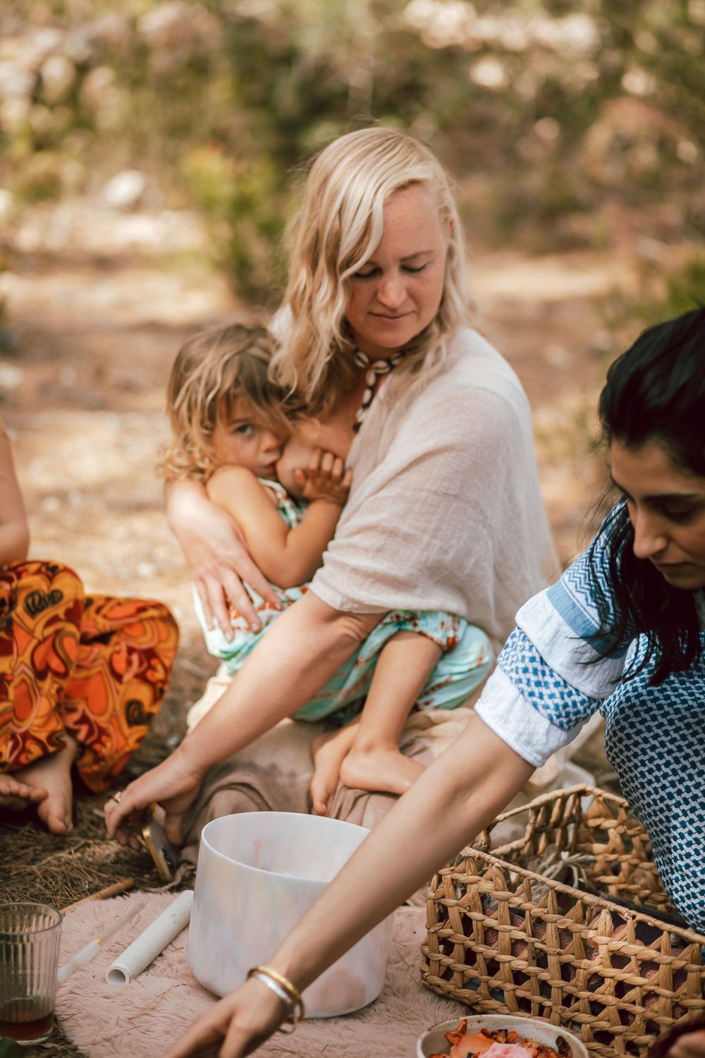 Group gathered around woven baskets in outdoor setting.