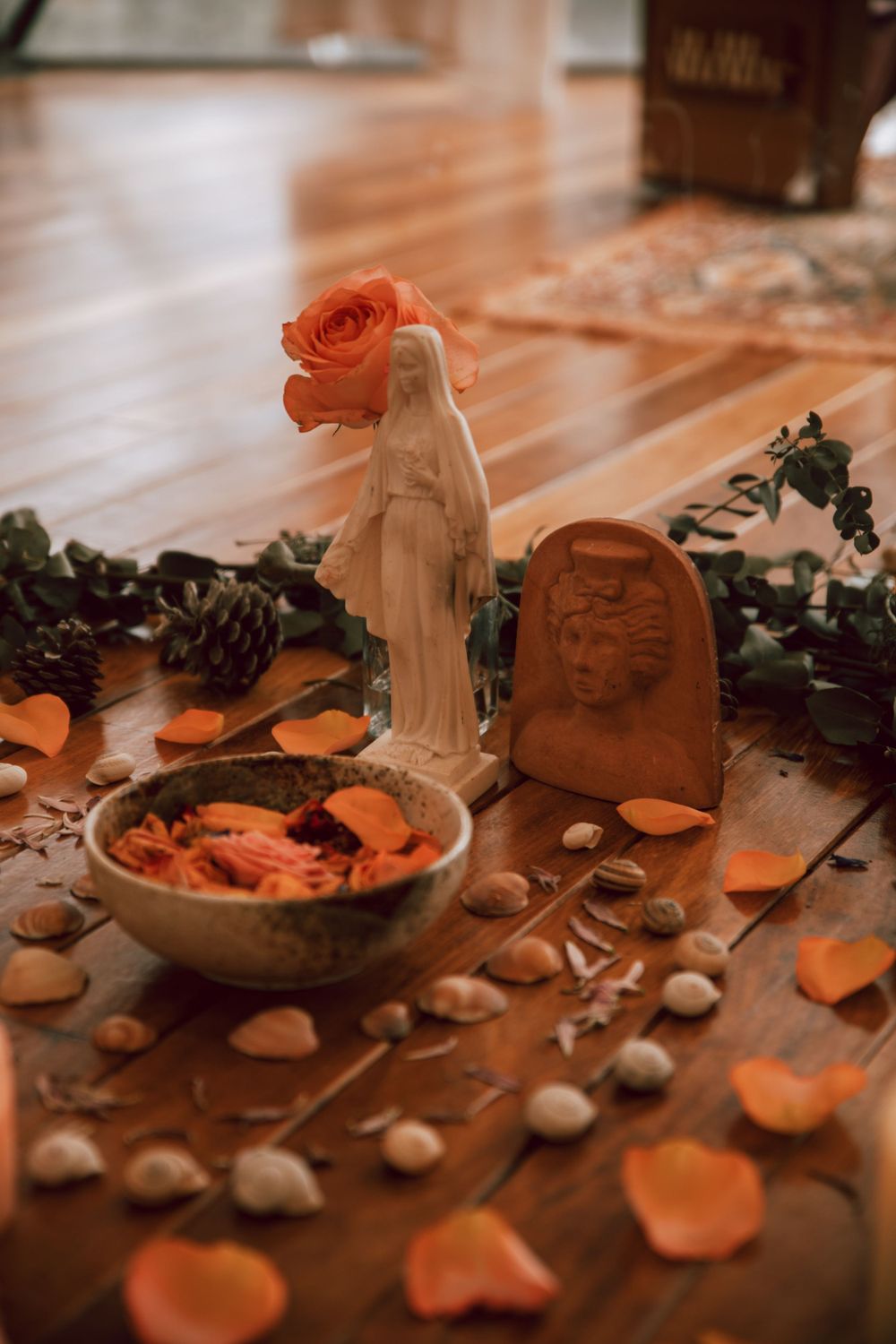 Decorative table setting with rose petals and ceramic figurines.