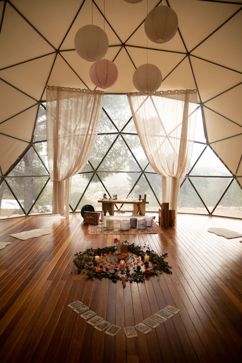 Geometric dome interior with hardwood floors and sheer curtains creating a serene space.