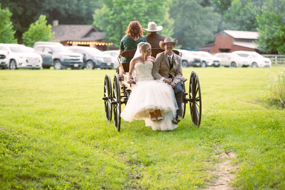 A country bride and her new groom are carried away in the back of her father's horse drawn wagon right after their vows.