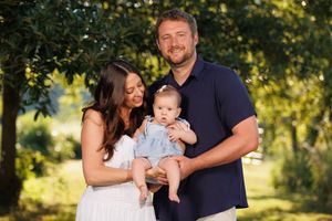 A couple happily poses with their first baby.