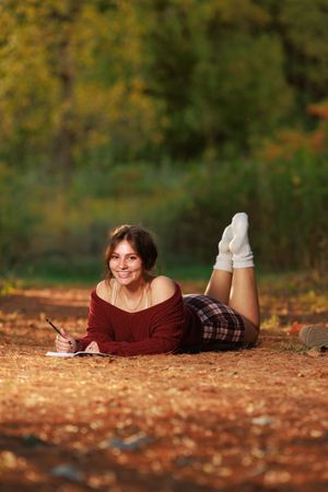 A girl lays amidst the pine needles for an evening portrait.