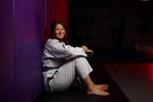 A high school senior girl posing for her senior portraits in a Jui jitsu outfit.