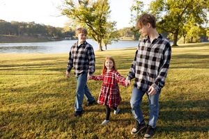 Siblings walking hand in hand next to Lake Sara in Effingham, Illinois.