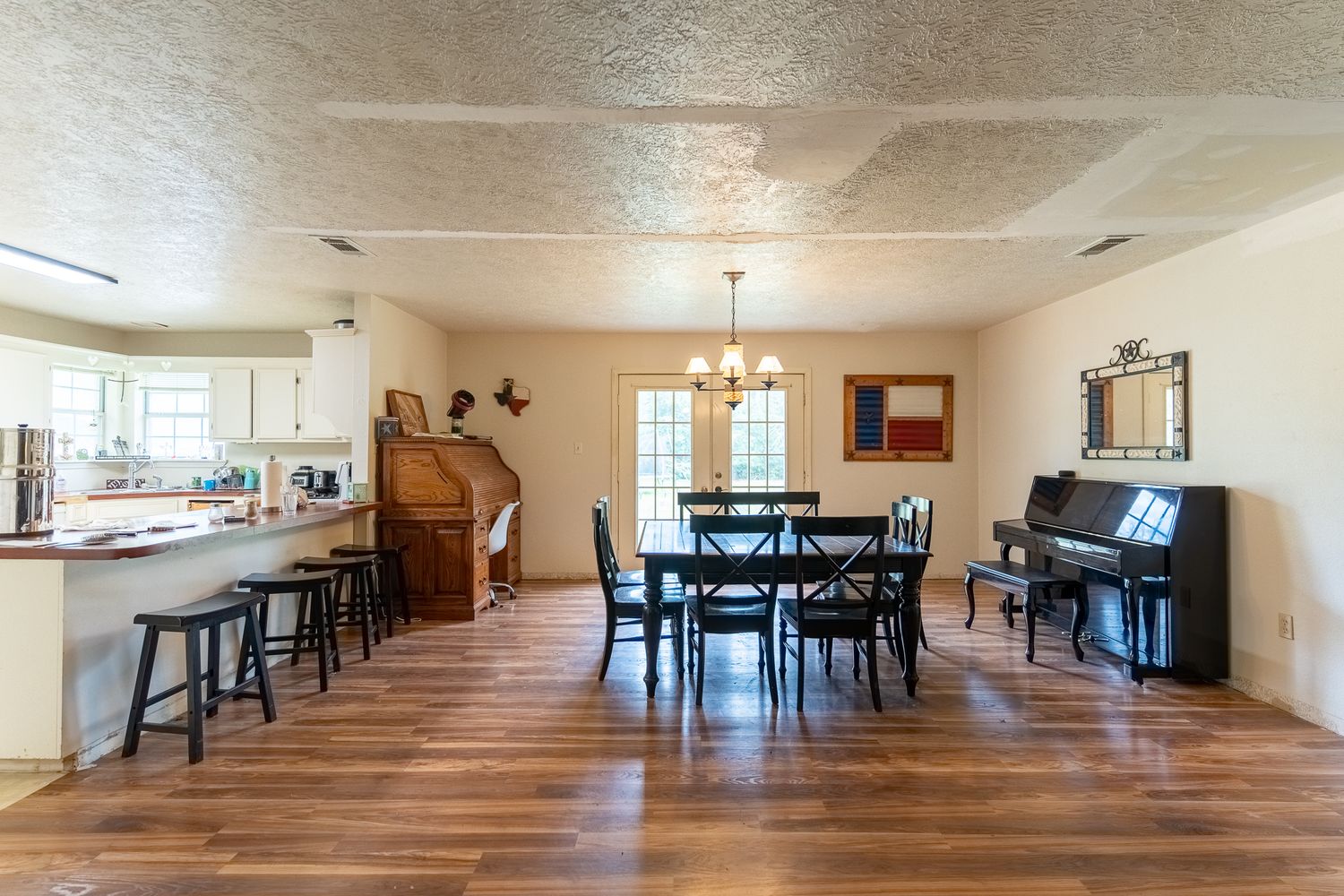 Open concept living space with hardwood floors, dining area, and upright piano.
