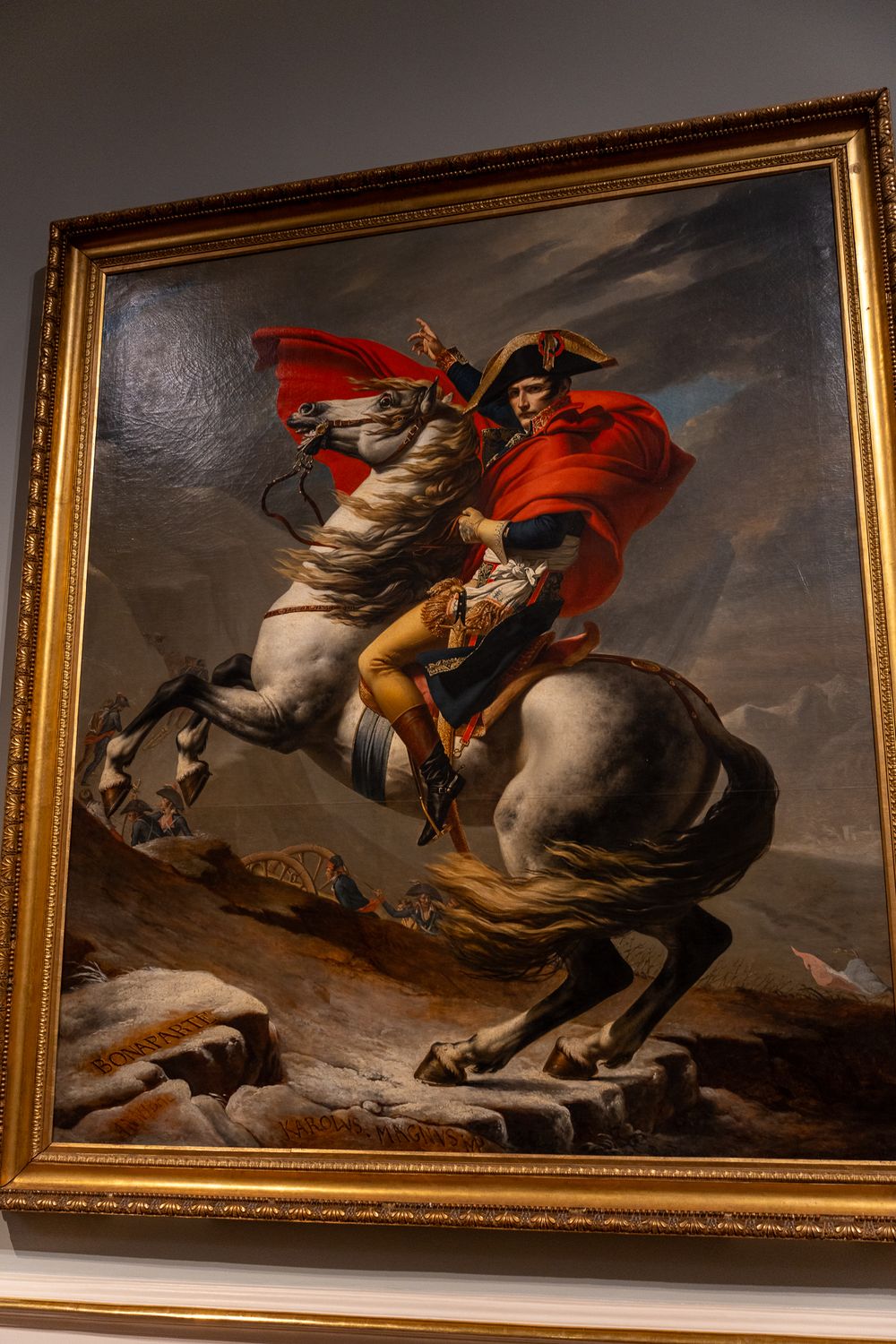 Famous painting of Napoleon crossing the Alps on horseback in an ornate gold frame.