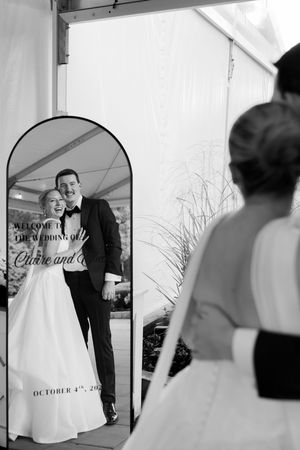 Husband and wife looking into their decorated mirror.