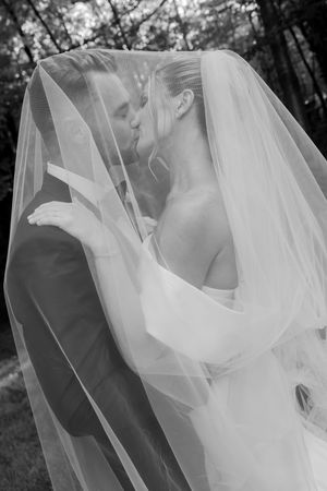 Black and white wedding photos showing romantic kiss moments through a flowing veil.