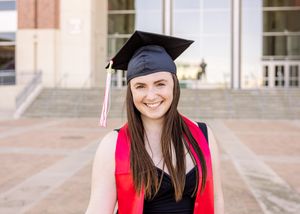 university college graduate smiling with cap and stole