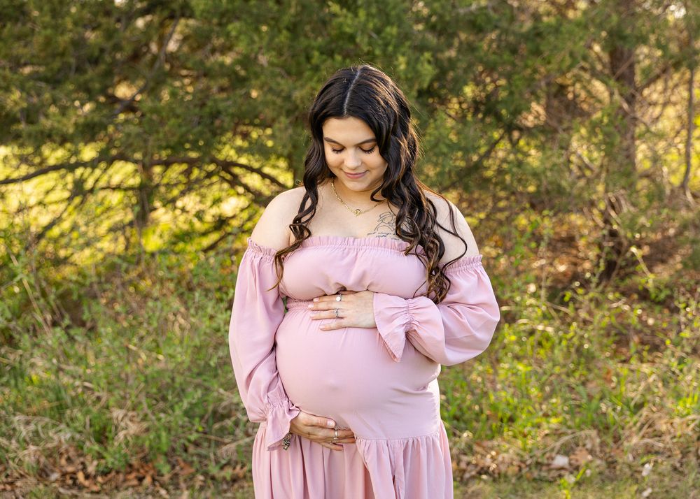 expecting mother holding her belly posing for a picture