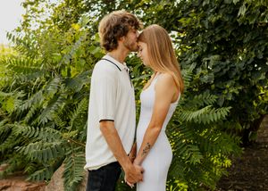 newly engaged couple kissing and holding hands