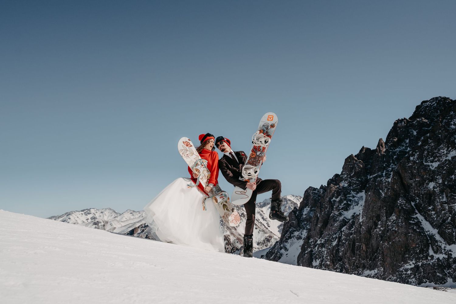 Engagement of a snowboarding couple in the snowy mountains