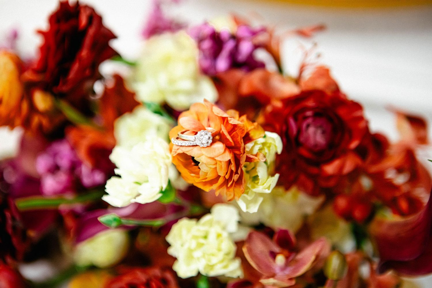 Vibrant red and purple flowers arranged in a romantic wedding bouquet display.