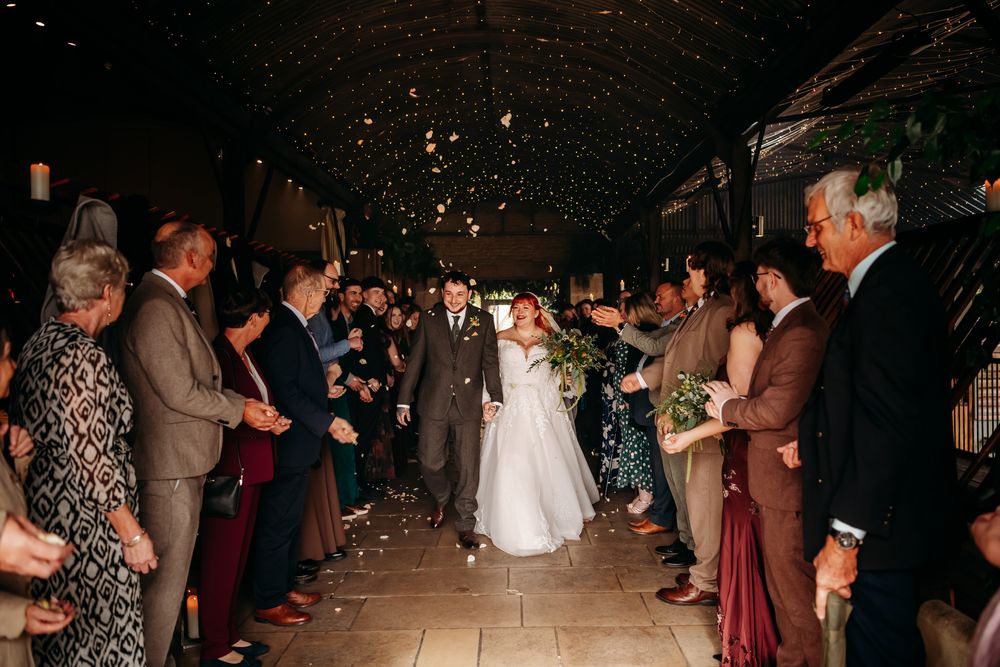 Couples dance together on a dimly lit dance floor during a wedding reception celebration.