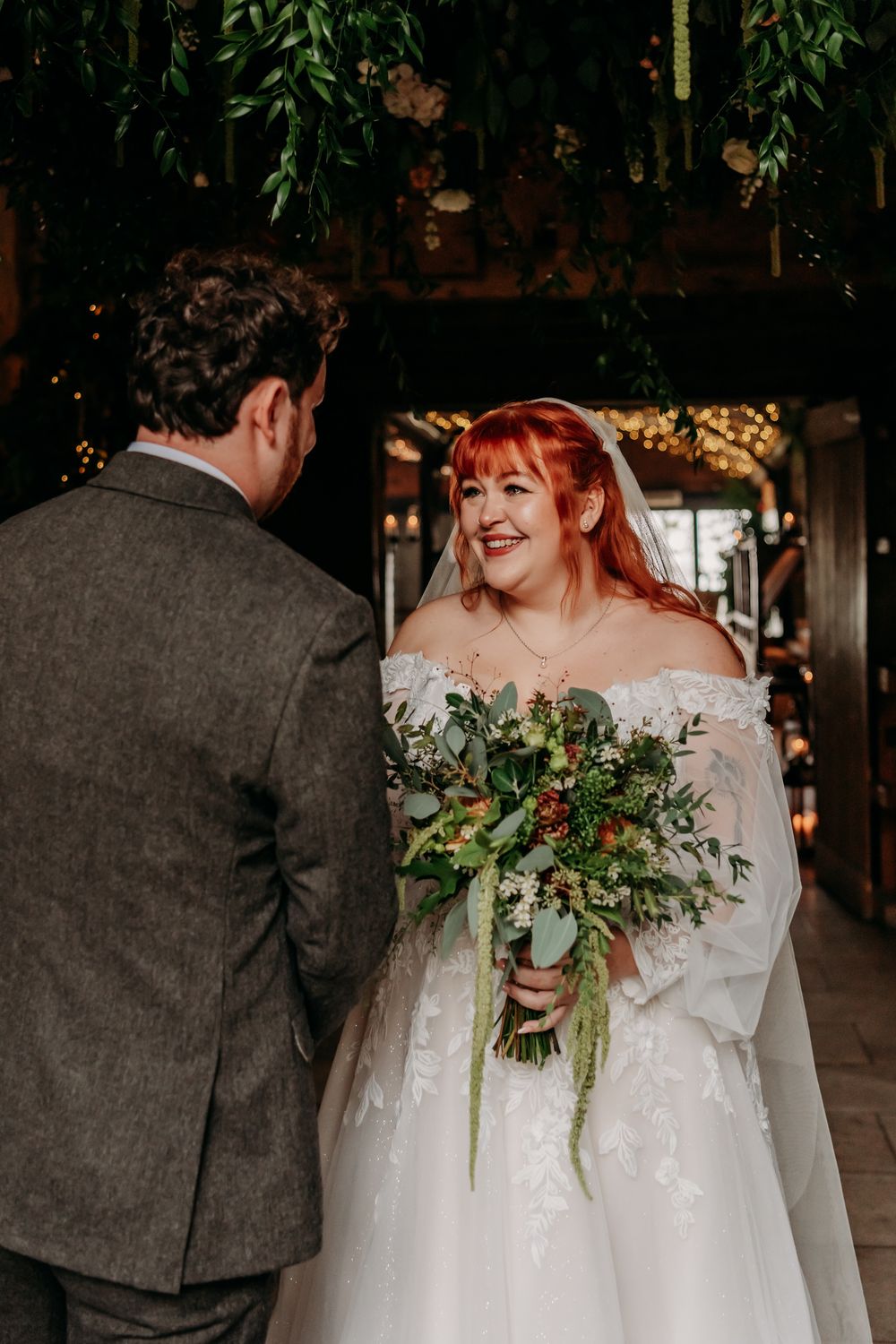 Close-up shots of a bride in a white dress with a natural greenery bouquet against a dark rustic background.