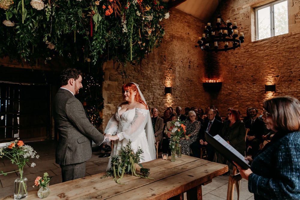 Rustic industrial wedding venue with exposed brick walls and hanging lights creates an intimate atmosphere for a celebration.