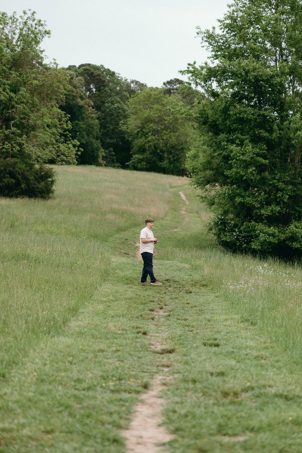 A winding dirt path leads through a grassy meadow with trees in the background. Le Château du Cœur Wedding Photographer