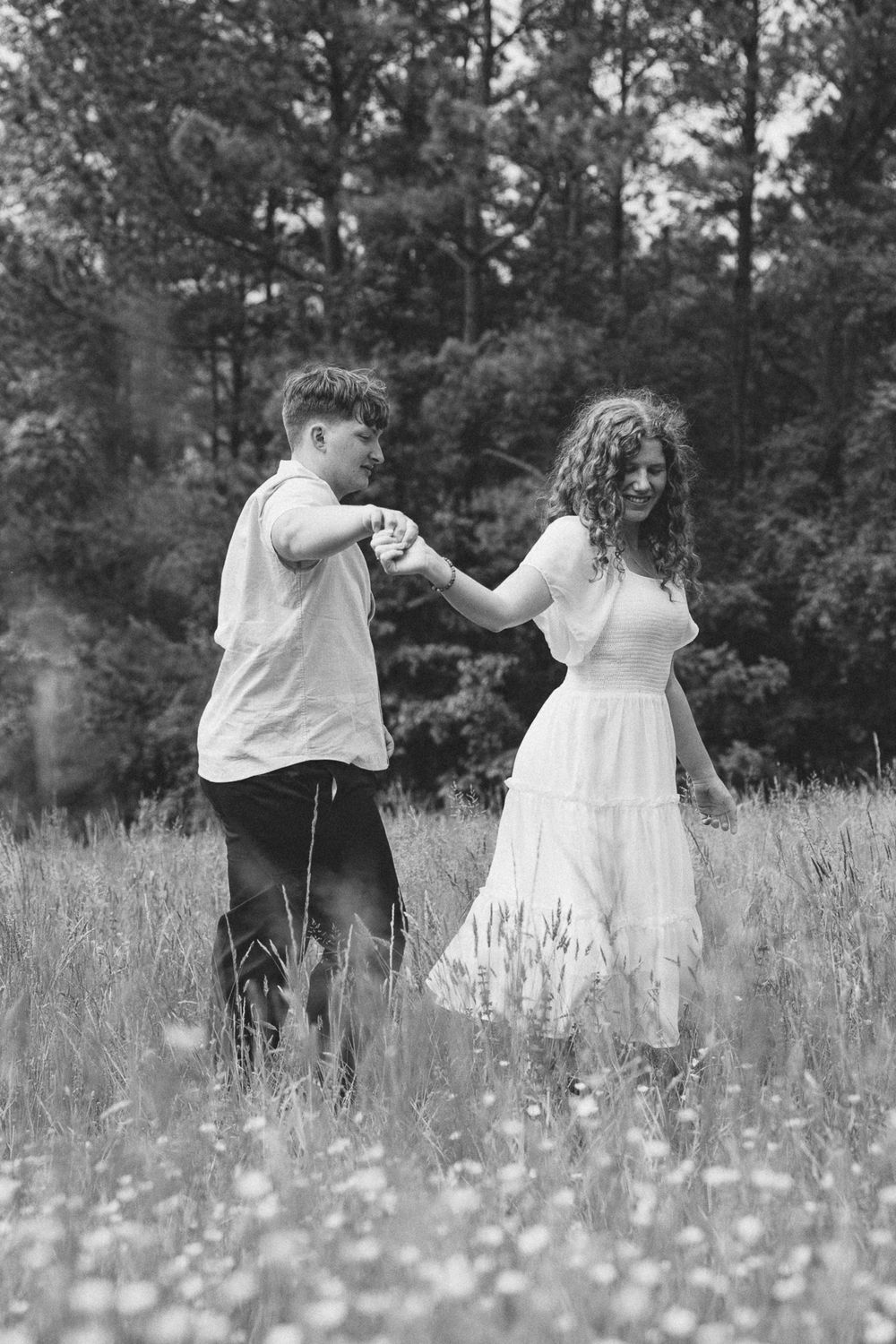 Black and white photo of two people dancing in a field of wildflowers. Le Château du Cœur Wedding Photographer