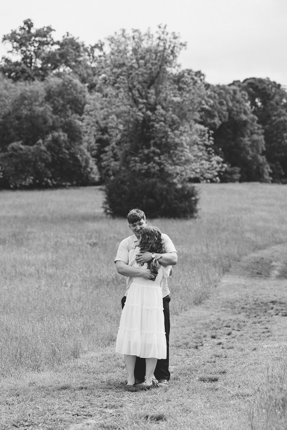 A romantic black and white photo captured in a serene meadow setting. Le Château du Cœur Wedding Photographer