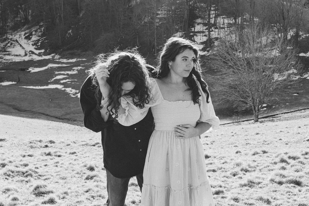 A couple shares an intimate moment on a hillside with mountains in the background. Castle  Ladyhawke Wedding Photographer