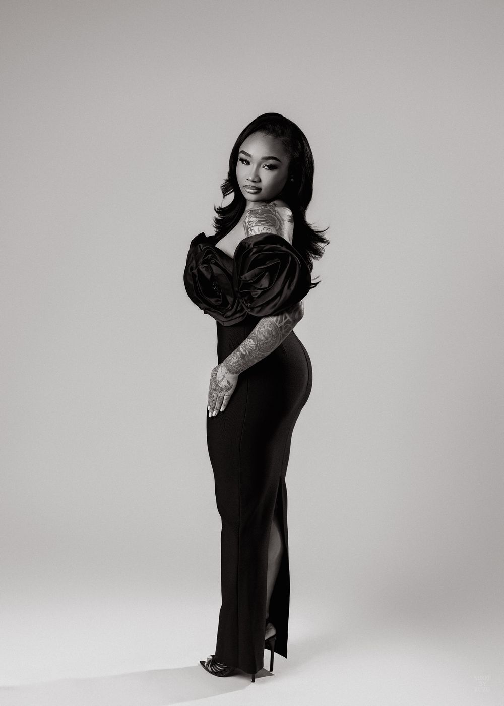 A fashion photoshoot series featuring someone in a long black dress posing elegantly against a white backdrop.