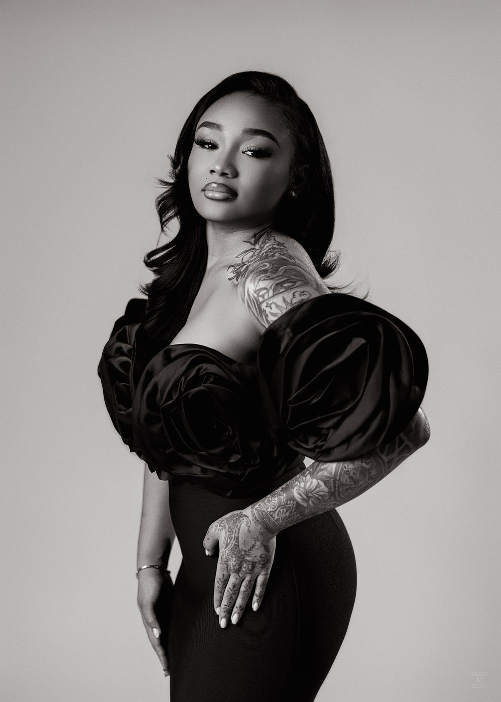 Black and white photo series showing a person in dark clothing posing elegantly against a light background.
