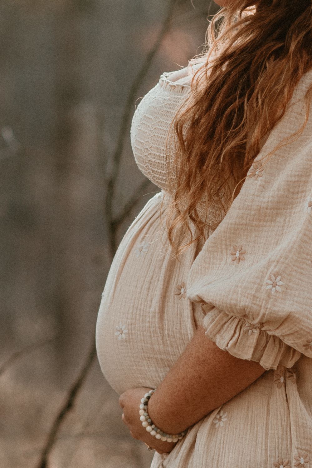 Close-up details of a white lace maternity dress with delicate embroidery.