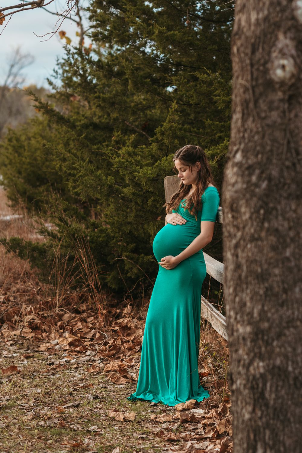 A sequence of photos showing a person in a bright emerald green dress posing outdoors among trees and fallen leaves.