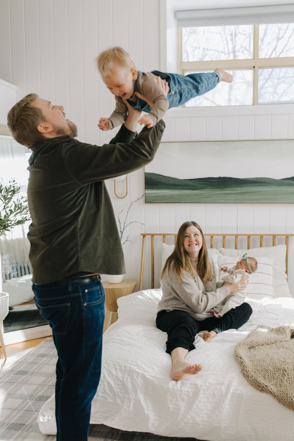 Playful family interaction sequence showing lifting and playing with small child.