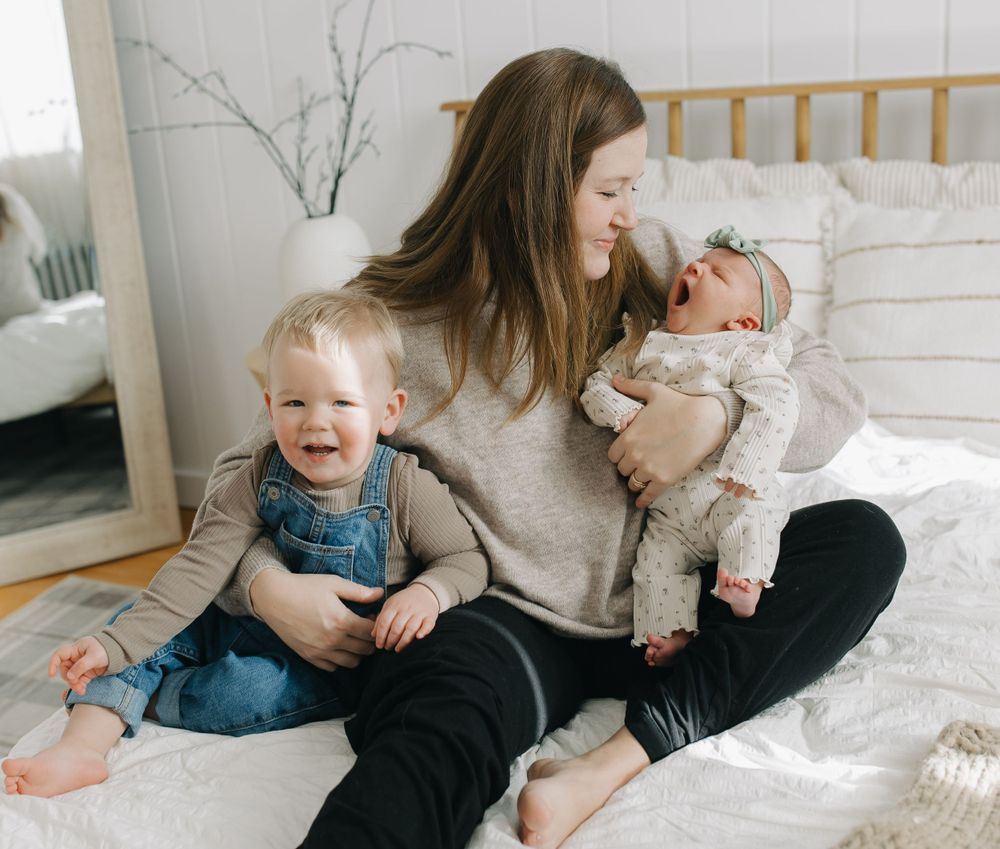 Casual family moments captured in a bright, modern bedroom setting.