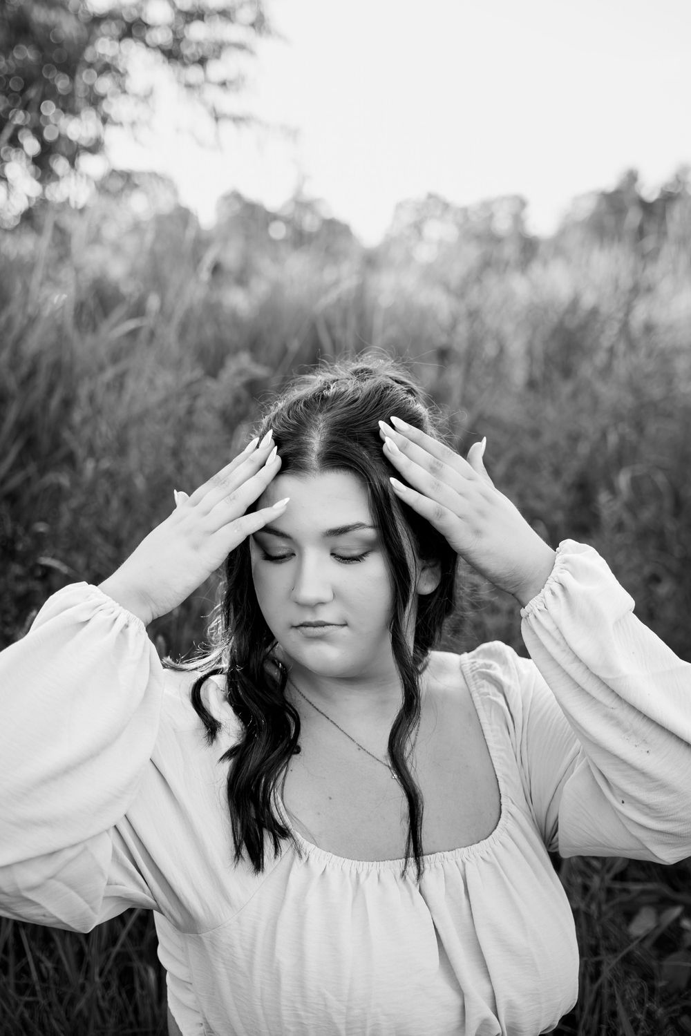 Black and white portraits in a flowing white dress against natural scenery.