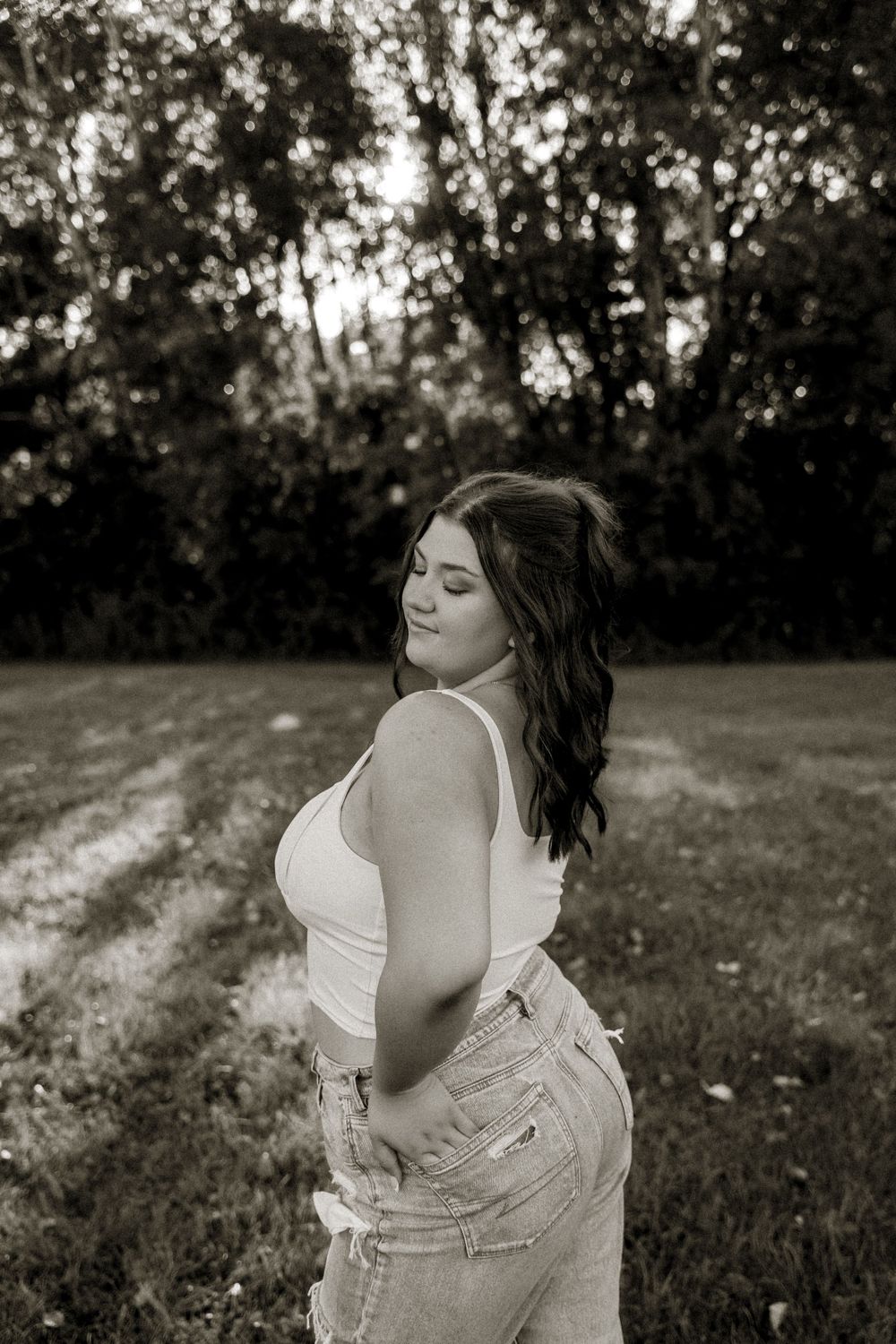 Outdoor portrait session in black and white featuring a white dress against a natural background.