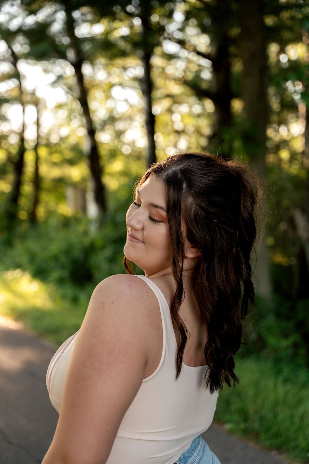 Artistic outdoor photoshoot with soft lighting and natural forest backdrop.