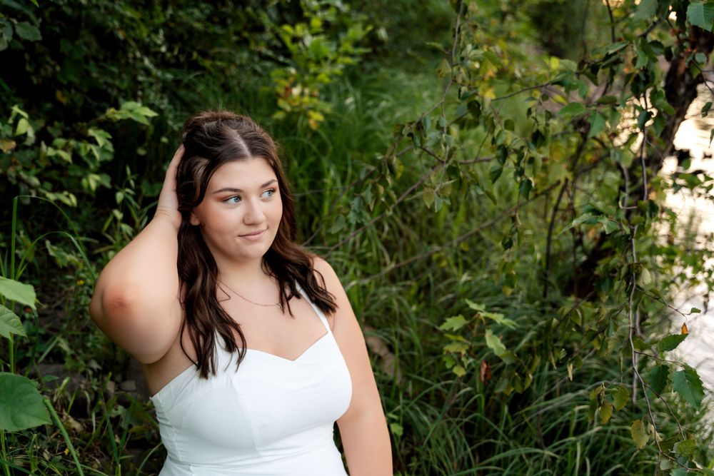 Outdoor photography session with white clothing against green natural backdrop.
