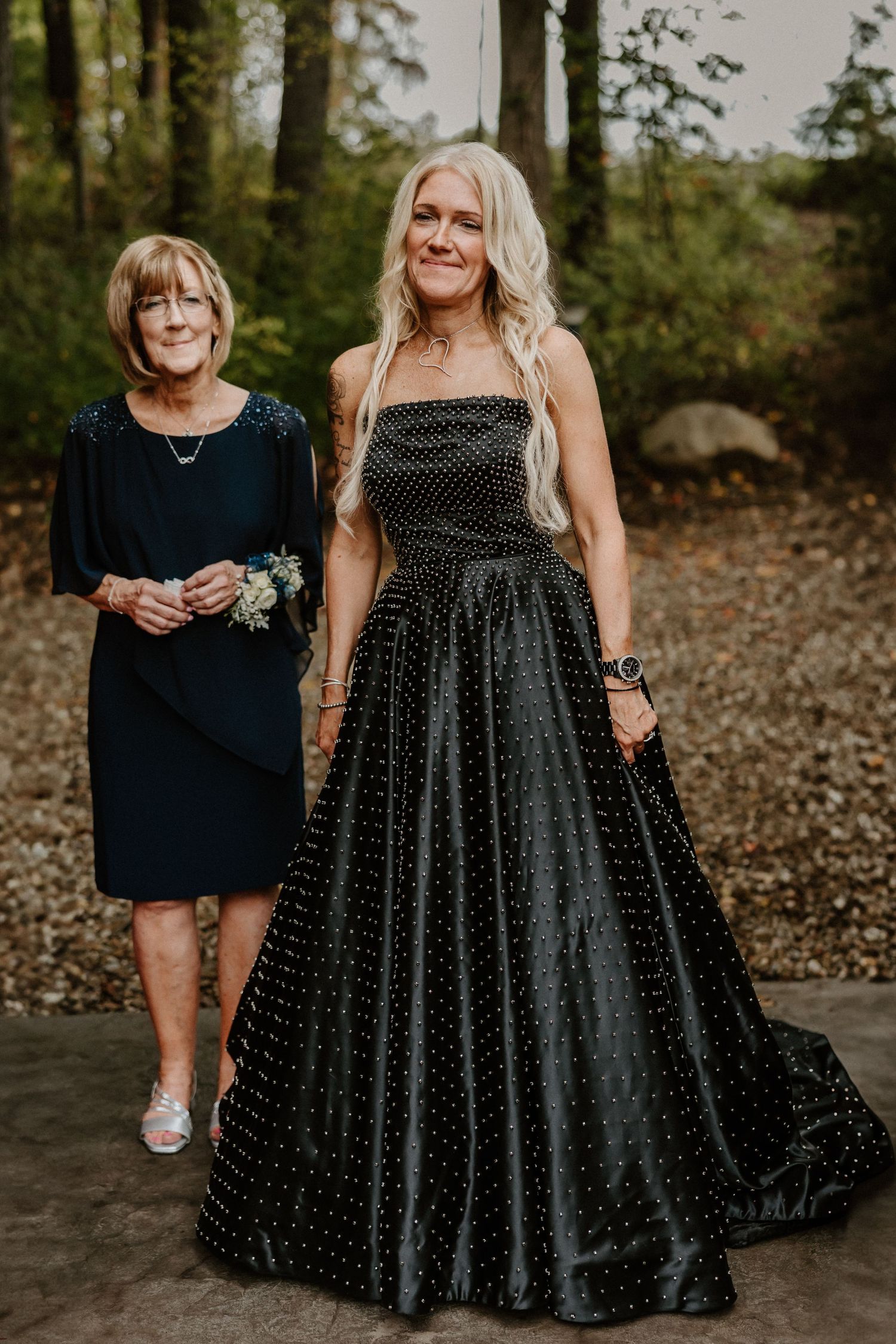 Two women pose outdoors, one wearing a stunning black polka dot ballgown.