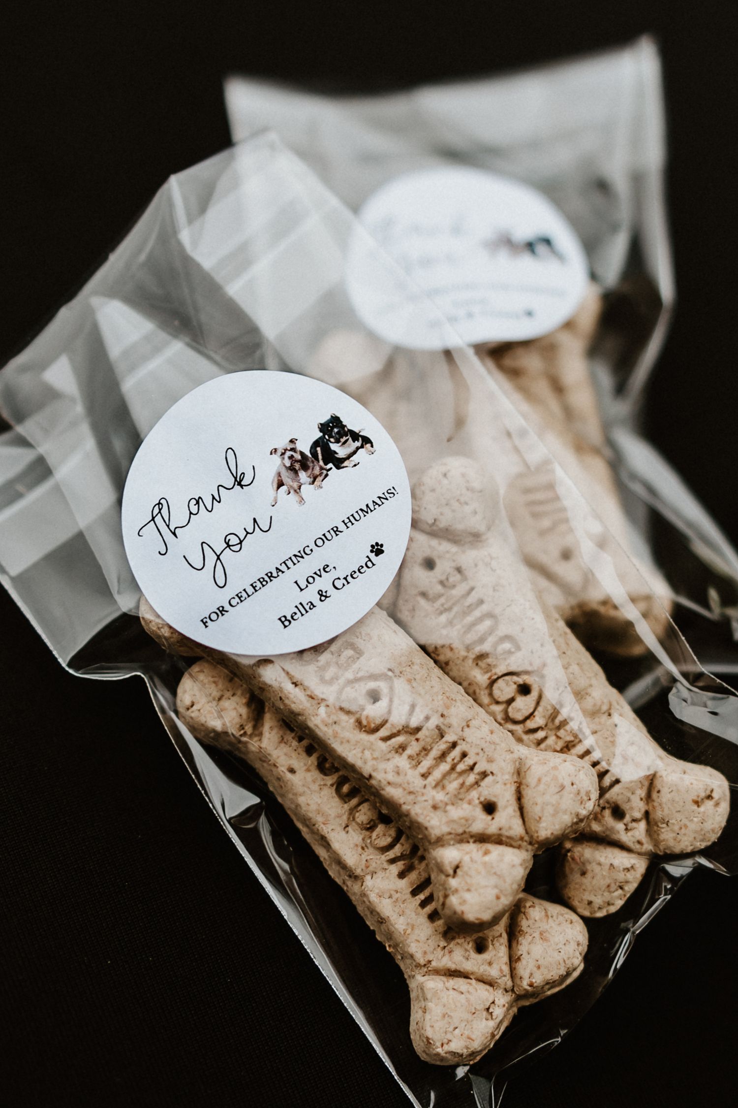 Bone-shaped dog treats packaged in clear bags with 'Thank You' stickers for wedding favors.