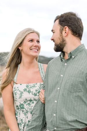 Romantic engagement photo series showing couple in matching green plaid and floral outfits looking lovingly at each other outdoors.